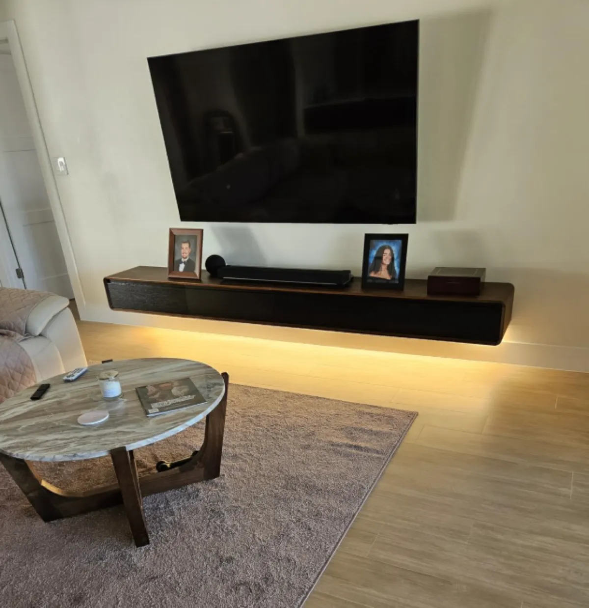 Floating walnut console with soundbar and wall sconces