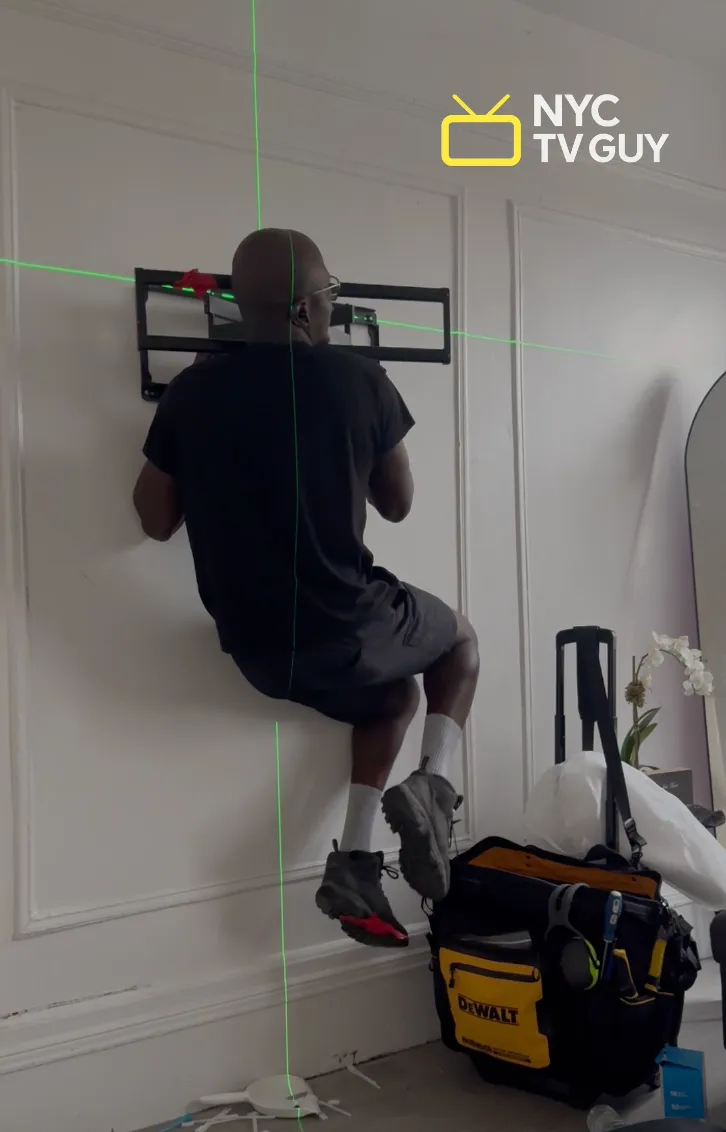 NYC TV Guy technician installing TV mount with laser level