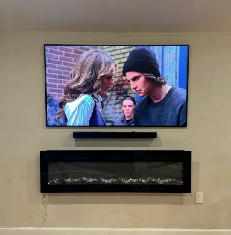 TV and soundbar mounted above fireplace