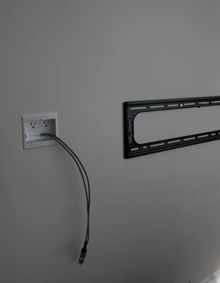 In-wall power outlet and cable plate with TV mount bracket