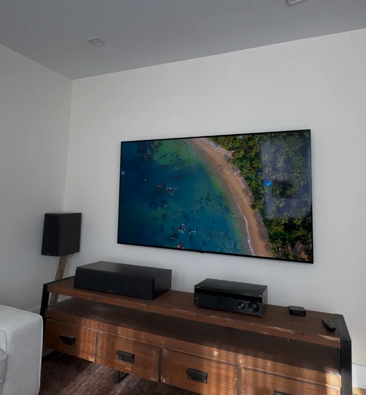 Large TV mounted above media console with surround sound